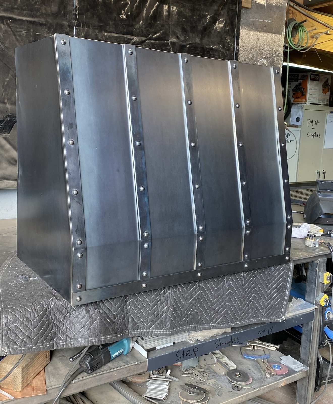 Riveted steel range hood with patina