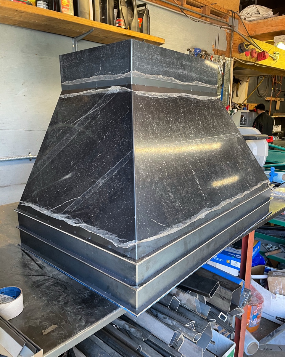 Custom black range hood fabricated by Pro Form Metals
